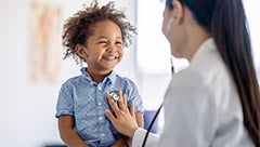 Insurance coverage during transitions: Evidence from Medicaid automatic enrollment for children receiving supplemental security income. Stock image shows child being examined by a pediatrician
